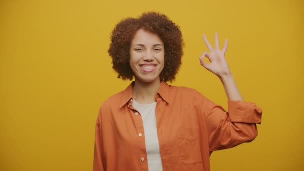 Γυναίκα Εμφάνιση Sign Gesture Yellow Background Κοιτάζοντας Κάμερα Fps Αργή — Αρχείο Βίντεο