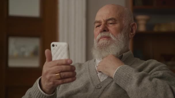 Starszy Mężczyzna Single Tap Smartfonie Dziadek Korzystający Smartfona Pomieszczeniach — Wideo stockowe