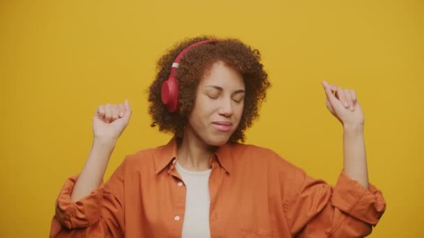 Vrouw Luister Naar Muziek Hoofdtelefoon Dans Gele Achtergrond Fps Slow — Stockvideo