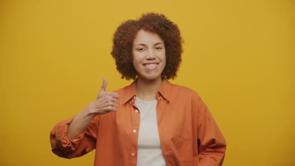 Jak Gesture Żółtym Tle Kobieta Pokazuje Kciuki Zwolnionym Tempie — Wideo stockowe