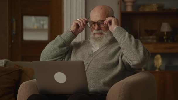 Anciano Poniéndose Gafas Abuelo Trabajando Ordenador Portátil Apartamento — Vídeos de Stock