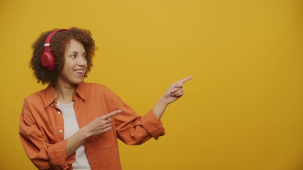Vrouw Punt Kopieerruimte Koptelefoon Gele Achtergrond Fps Slow Motion — Stockvideo