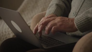 Yaşlı adam elleri daktiloda, dede kolları dizüstü bilgisayar klavyesinde.