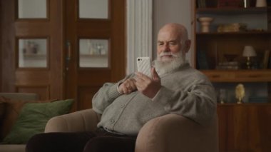 Üst Düzey Adam Apartman 'daki Koltukta oturan Akıllı Telefondan Olumlu Mesaj Okuyor