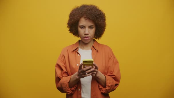 Frau Textet Auf Smartphone Und Feiert Auf Gelbem Hintergrund Erwachsene — Stockvideo