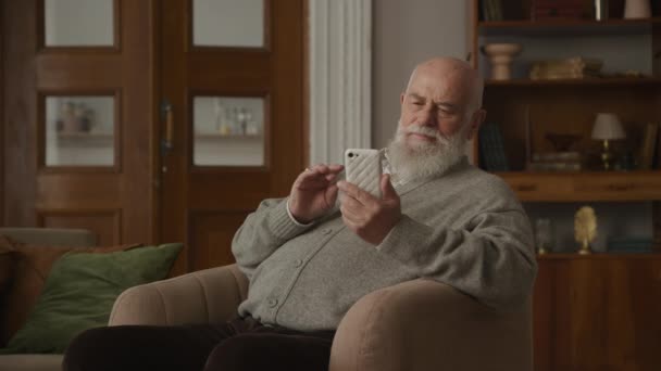 Senior Man Viert Prestaties Smartphone Grootvader Lezen Goed Nieuws Zittend — Stockvideo