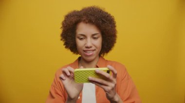 Sarı Arkaplanda Yatay Akıllı Telefon 'da Kadın Sörfü, Akıllı Telefona Bakan Kadın