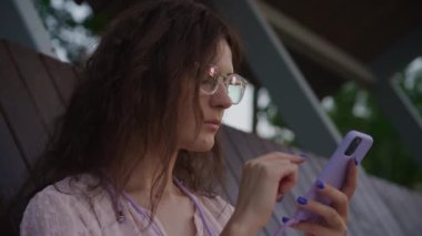 Gözlüklü Kadın Parktaki Akıllı Telefona Bakıyor, Kız Öğrenci Sörf Yapıyor Çevrimiçi Akıllı Telefonu Açık havada Kullanıyor