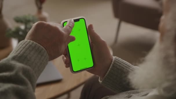 老年人擦拭和点击绿色屏幕智能手机 在Chroma键智能电话浏览的肩部视图 — 图库视频影像