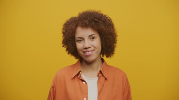 黄色の背景に女性のウィンクと笑顔 遊び心のある気分の女性 — ストック動画
