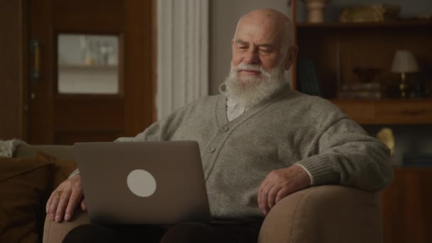 Senior Telefoniert Mit Laptop Großvater Sessel — Stockvideo
