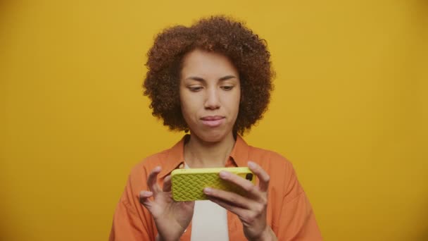 Tilfredsstillende Kvinnelig Bruning Horisontal Smarttelefon Yellowbackground Fps Sakte Film – stockvideo