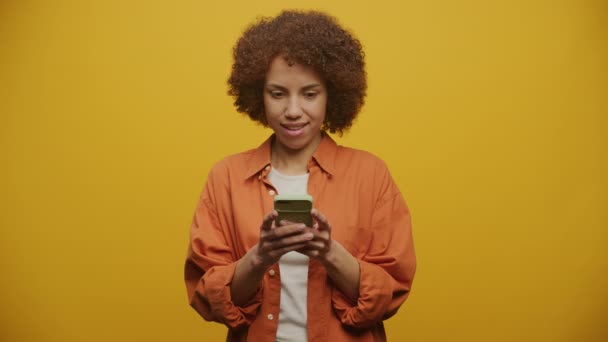 Przemyślana Kobieta Wpisując Wiadomość Smartfonie Żółtym Tle Kobieta Myśląca Odpowiedź — Wideo stockowe