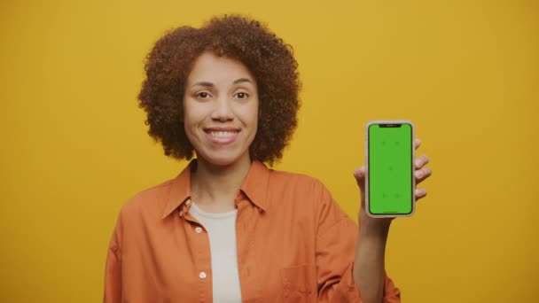 Feminino Apontando Dedo Para Chroma Key Smartphone Fundo Amarelo — Vídeo de Stock