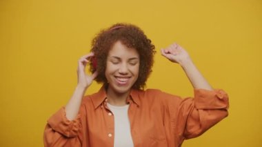 Neşeli Kadın Sarı Arkaplanda Müzik ve Dans Dinliyor, Kırmızı Kulaklıklı Kadın