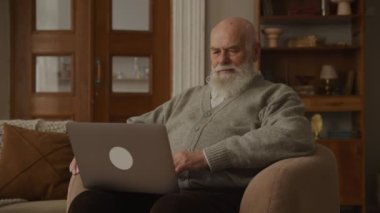 Yaşlı adam Kol Sandalyesinde Dizüstü bilgisayar kullanıyor, Büyükbaba Bilgisayar okuyor