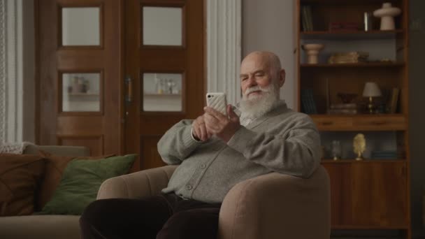 Senior Man Reading Good News Smartphone Apartment Grandfather Celebrating Achievement — Wideo stockowe