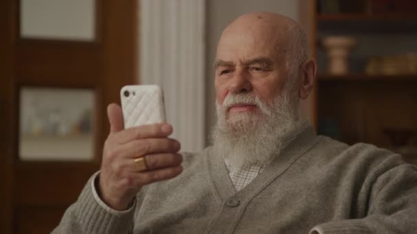 Дедушка Помощью Смартфона Крупным Планом Вдумчивый Старший Человек Просмотра Интернете — стоковое видео