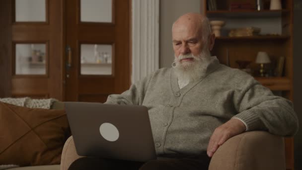 Dziadek Czytaj Złe Wieści Laptopie Fotelu Zdenerwowany Senior Man Otrzymuj — Wideo stockowe