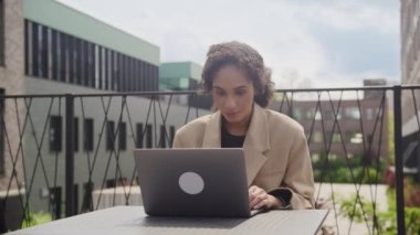 İş kadını başarıyı kutluyor, kadın dışarıda laptopta iyi haberler okuyor.