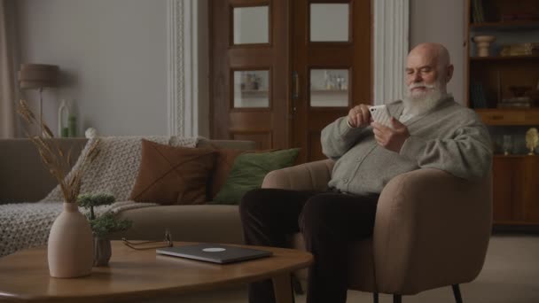 Grandfather Answering Phone Call Sitting Armchair Elderly Man Raising Phone — Stock Video