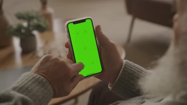 Над Плечом Просмотр Старший Человек Просматривает Зеленом Экране Смартфона Квартире — стоковое видео