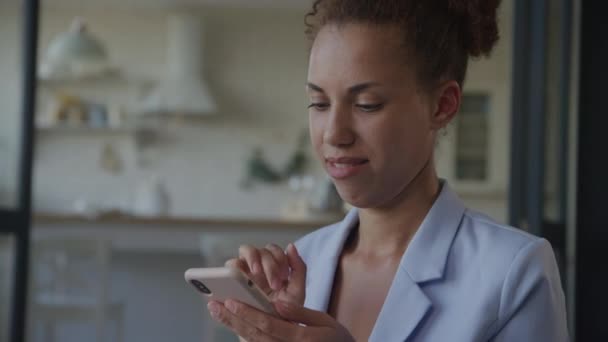 スマートフォンとスマイルでテキストする女性の周りを周回 スマートフォンインデオを使用してビジネスマン — ストック動画