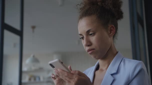 スマートフォン上の疑問のブラウジングで女性 低角度ビュー 感情でスマートフォンを使用して女性 — ストック動画