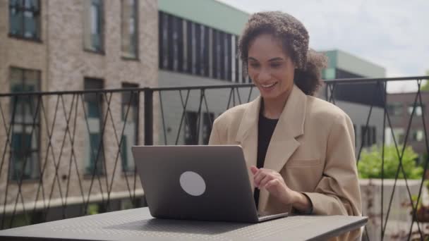 コンピュータアウトドアを使用して笑顔のビジネスマンラップトップで働く功績を祝う幸せな女性 — ストック動画