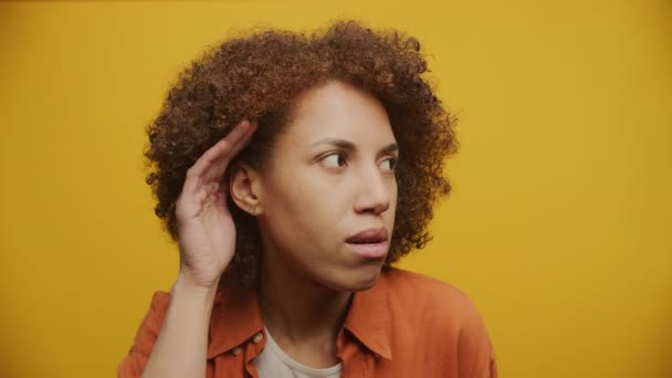 イエローバックゴンドの女性リスニングジェスチャー サインを聞こうとしている女性 — ストック動画
