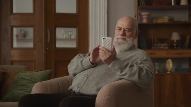 Großvater Liest Gute Nachrichten Auf Smartphone Drinnen Senior Erhält Positive — Stockvideo