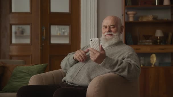 Großvater Drückt Daumen Wie Geste Mit Smartphone Sessel Senior Liest — Stockvideo