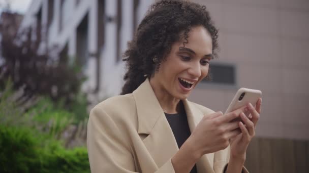 商界妇女在外面的智能手机上庆祝成就 妇女在智能手机上获得工作机会 妇女阅读好消息 — 图库视频影像