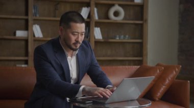 Ofiste dizüstü bilgisayarda çalışan odaklanmış adam, Bilgisayarda yazan işadamı