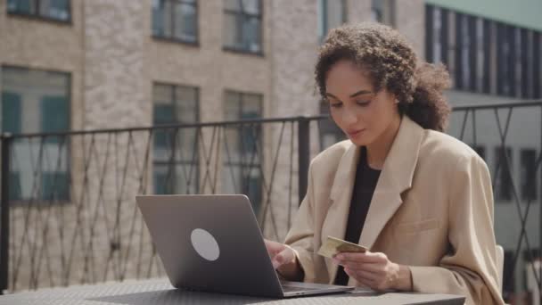 Weibliche Eingabe Von Kreditkarteninformationen Mittels Laptop Der City Street — Stockvideo