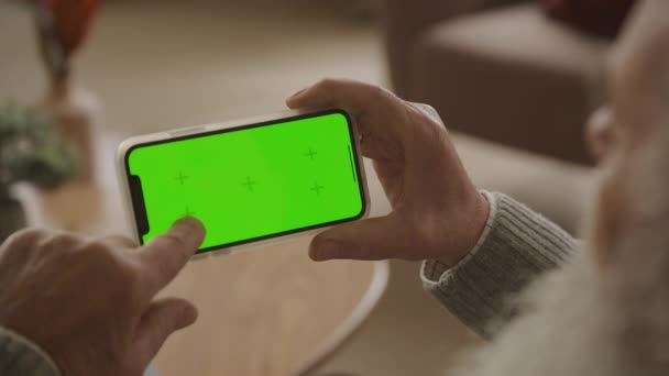 Browsing Horizontal Green Screen Smartphone Indoors Grandfather Holding Chroma Key — Stock video
