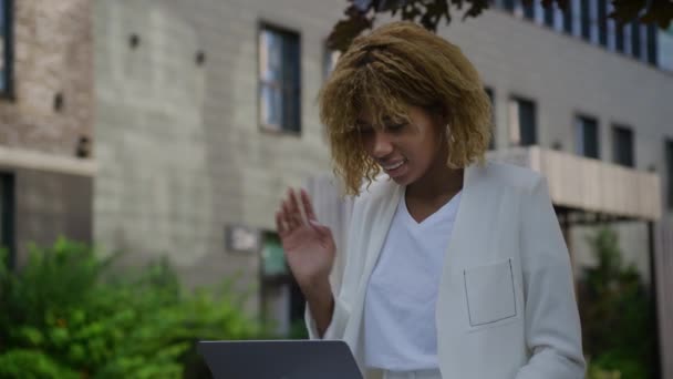 ビデオ会議で女性挨拶 ダウンタウンパークの外でラップトップを使用して電話 ビジネスウーマン オンライン — ストック動画