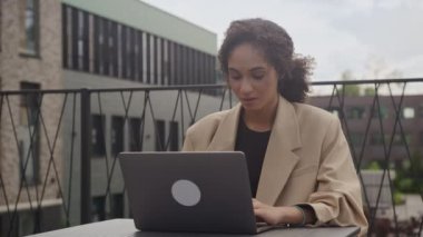 Üzgün iş kadını laptopta çalışıyor, mutsuz kadın uzaklara bakıyor.