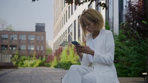 商界妇女在智能手机室外接受工作机会 阅读好消息和庆祝成就 — 图库视频影像