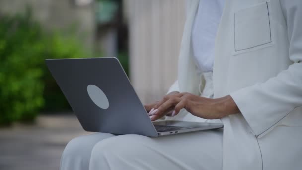 ラップトップのキーボードの女性ハンドタイピング アウトドアを閉じる 彼女の膝にコンピュータを使用するビジネスマン — ストック動画