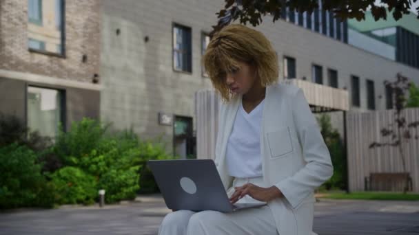 ビジネスウーマン ラップトップアウトドアでオンラインブラウジング シティダウンタウンの外でコンピュータを使用して女性 — ストック動画