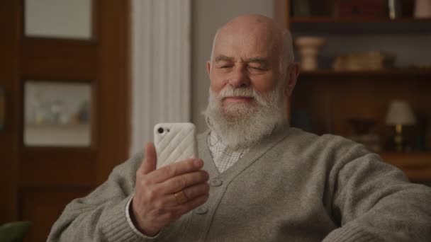 Senior Liest Auf Smartphone Wohnzimmer Aus Nächster Nähe — Stockvideo
