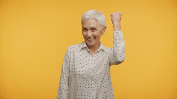 Seniorin Feiert Errungenschaften Auf Gelbem Hintergrund Gewinnerin Mittleren Alter — Stockvideo