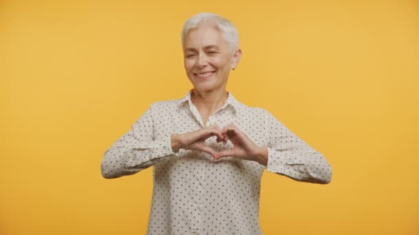 Starší Žena Ukazuje Srdce Gesto Žlutém Pozadí Středního Věku Matka — Stock video