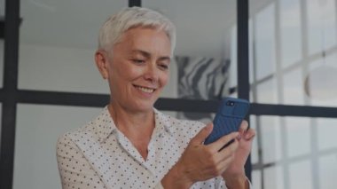 Gülümseyen Kıdemli Kadın Smartphone 'da İnternet' te geziyor, Beyaz Saçlı Modern Orta Çağ Kadını Akıllı Telefon Kullanıyor