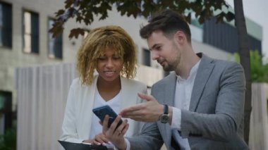 Meslektaşlar Borsa Haberlerini Dışarıda Akıllı Telefon Kullanarak Tartışıyor, İş Adamı ve İş Kadını Dışarıda Konuşuyor