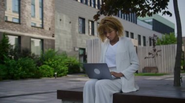 Şehir merkezindeki laptopta çalışan girişimci, İş kadını Ofis Parkı 'nda Bilgisayarda Yazıyor