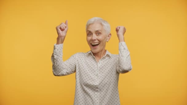 Reife Frau Feiert Frohe Botschaft Auf Gelbem Hintergrund — Stockvideo