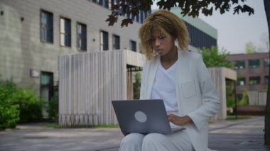 Şehir merkezinde dizüstü bilgisayar kullanan bir kadın internette geziniyor.