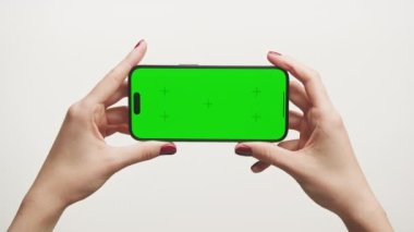 Beyaz Arkaplanda Yatay Yeşil Ekran Akıllı Telefon POV, İşaretleyicilerle Kroma Anahtarı Tutan Kadın Telefonu
